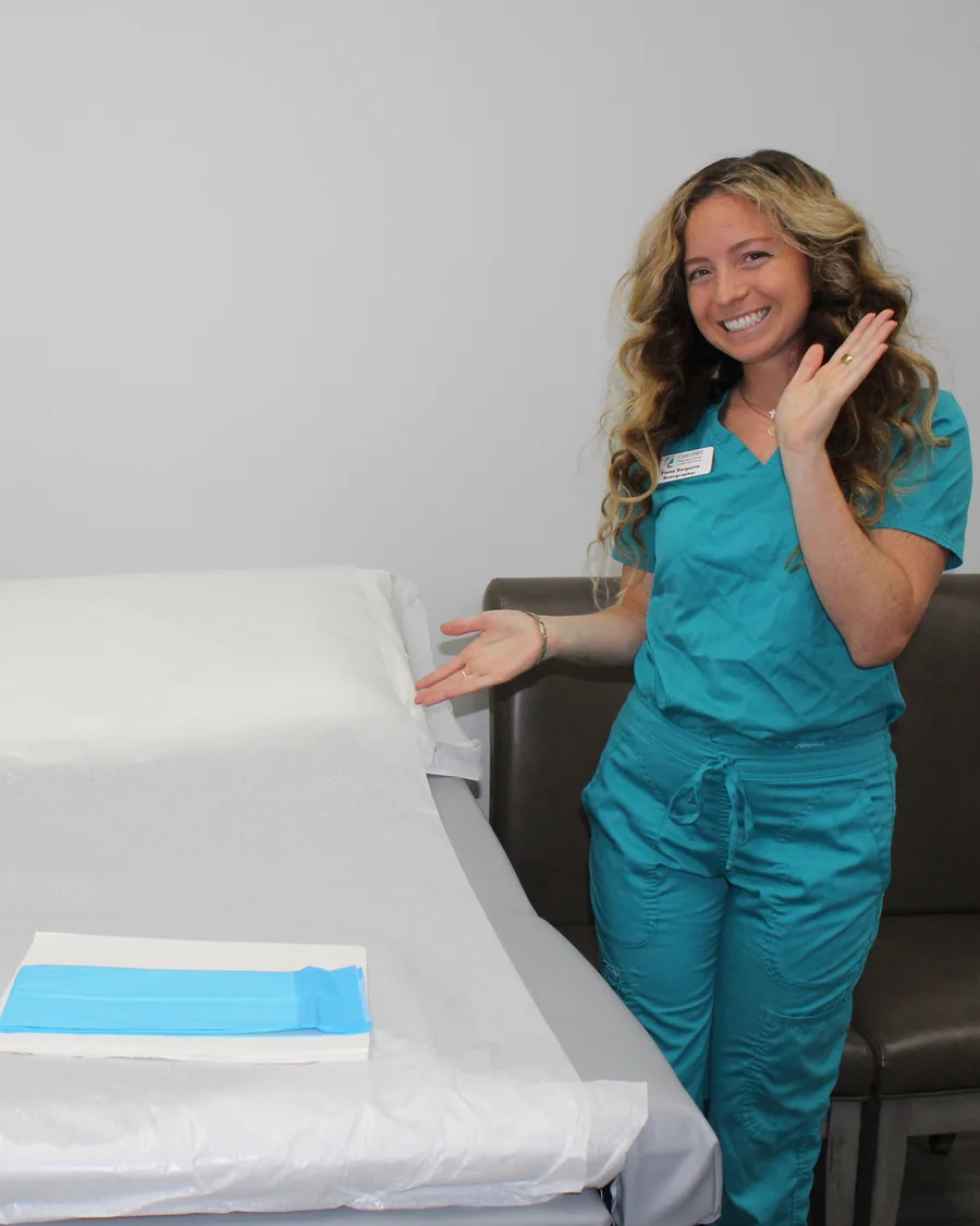A Care Net team member beside an examination table.